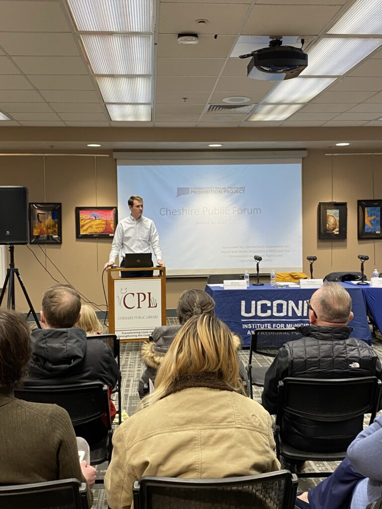Man standing in front of crowd at the chesire public library for the forum