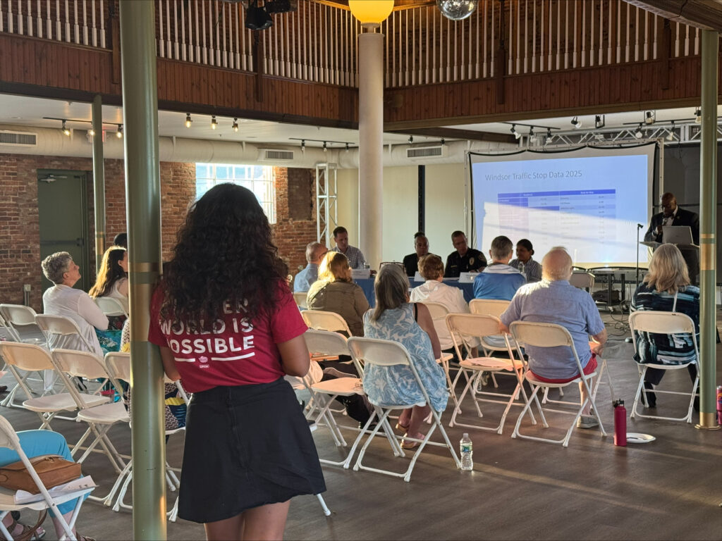 People sitting in a room facing a presentation screen